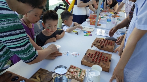 지난 13일 대전 대덕구가  금강변 산호빛공원에서 학습동아리들과 지역주민이 함께 어우러진 '2018 대덕生동 으랏차차' 축제를 개최했다. 사진은 어린아기가 체험부스에서 설명을 듣고 있다.
