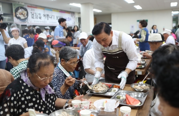 20일 아우내은빛복지관이 건강한 여름나기 보양식 나눔행사를 진행한 가운데 구본영 천안시장이 배식 봉사를 진행해 어르신들에게 삼계탕을 나눠주고 있다.