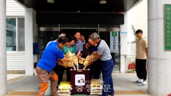제천시 봉양읍 단체장들이 준비된 다함께 나눔 쌀통에 쌀을 재우고 있다.