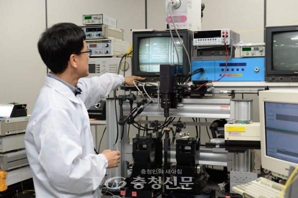 ETRI 김진태 박사가 이번에 개발된 광소자의 형상을 현미경으로 관찰하는 모습.