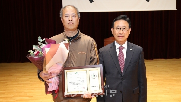 김영훈씨(왼쪽)가 이차영 괴산군수로부터 효행자 표창을 받고 기념 촬영을 하고있다
