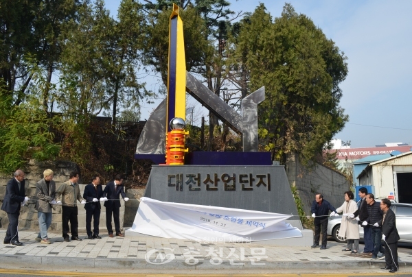 27일 대전산업단지 삼거리에서 대전산업단지관리공단 관계자들이 새 상징조형물 '하모니'의 막을 걷고 있다. (사진=이정화 기자)