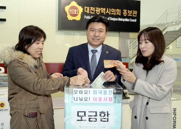13일 김종천 대전시의장(가운데)이 외국 동전 모으기 캠페인에 동참해 기부를 하고 있다. (사진=대전시의회 제공)