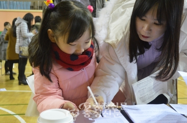 지난해 둔산초등학교에서 이뤄진 초등학교 예비소집에서 한 학생이 준비된 입학 서류에 어머니와 함께 본인확인을 하고 있다.(사진=한유영 기자)