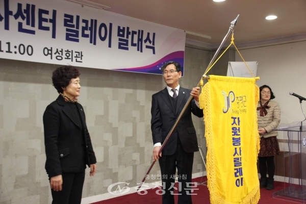 전병일 국장(가운데)이 김남순 센터장(왼쪽)에게 자원봉사 릴레이 기를 전달하는 모습. (사진=김정기 기자)