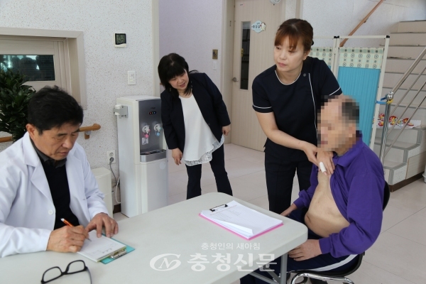8일 다정한마을에서 김주영 전문의가 시설 간호사와 함께 한 어르신의 피부 상태를 확인하고 있다. (사진=김정기 기자)