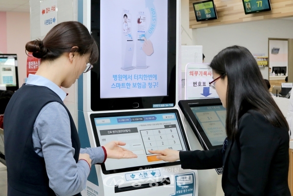 무인자동화기기(ATM)를 이용해 서비스를 이용하고 있는 모습.