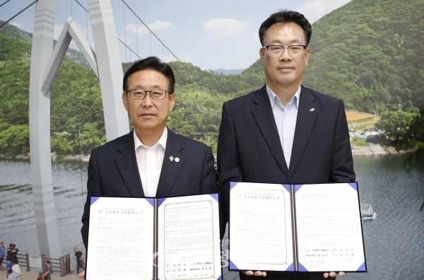 27일 이차영 괴산군수(왼쪽)와 경지호 LH충북지역본부장이 업무협약을 맺고 기념 촬영을 하고 있다.