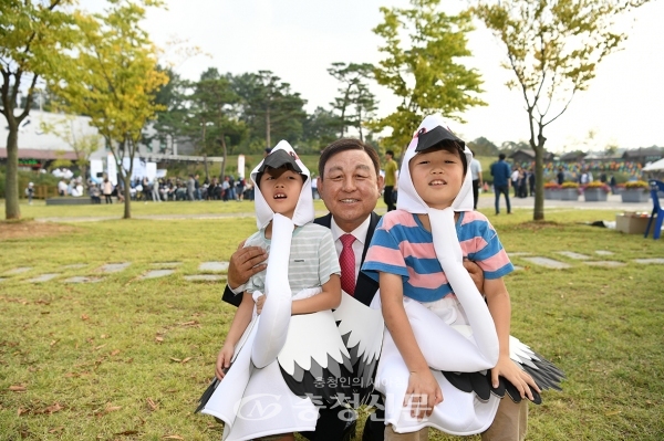 황선봉 군수가 황새 복장을 한 어린이들과 기념촬영을 하는 모습.