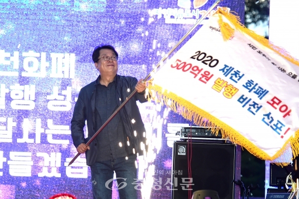 이상천 제천시장이 제천화폐 500억 원 달성 기원 깃발을 흔들어보이고 있다. (사진=제천시 제공)