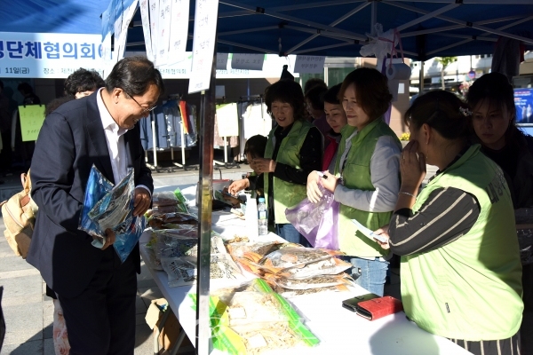 제천시여성단체협의회가 개최한 바자회 부스를 찾은 이상천 제천시장이 물건을 구입하고 있다. (사진=제천시 제공)