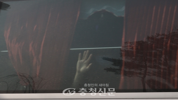 퇴소하는 한 우한 교민이 환송 버스 안에서 주민들에게 손을 흔들어 보이고 있다. (사진=김정기 기자)
