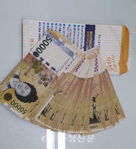 은행 봉투 채 책상 위에 놓여진 이웃돕기 성금 100만원 (사진=천안시 제공)