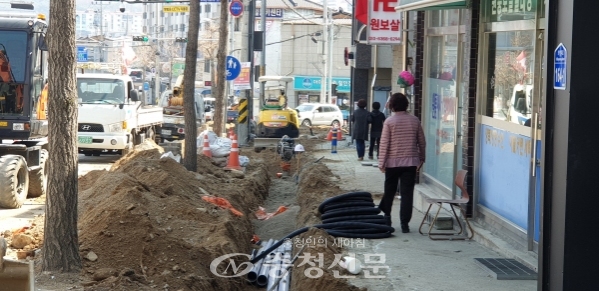 깊게 구덩이가 파인 제천시 남현동 지중화 공사 현장을 한 보행자가 불안하게 지나가고 있다. (사진=조경현 기자)