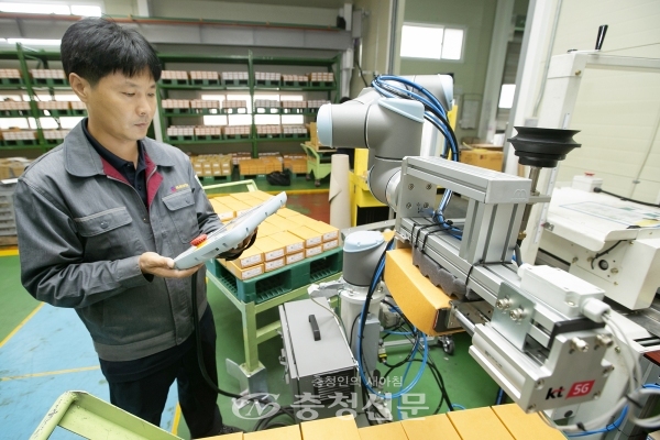 충북 제천에 있는 박원 공장에서 생산직 근로자가 KT 5G 스마트팩토리 코봇과 함께 작업을 하고 있다. (사진= KT충남/충북광역본부 제공)