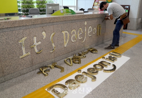 대전시청 1층 안내데스크에 부착된 브랜드 슬로건이 이츠대전(It's Daejeon)에서 대전이즈유(Daejeon is U)로 교체되고 있다.(사진=대전시 제공)