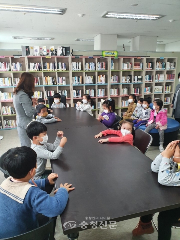어린이들이 독서지도자로부터 책에 대한 설명과 교육을 받고 있다.