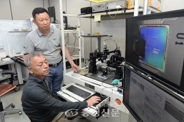 한국전자통신연구원(ETRI) 연구진이 나노정렬 패키징 장비를 이용해 실리콘 광집접회로 칩과 입출력 광섬유를 정렬하고 있다. (사진=ETRI 제공)