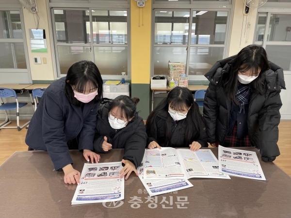 백제중학교에서 2020학년도를 되돌아보는 영자신문을 발간해 화제가 되고 있다. 만들어진 영자신문을 보고 있는 학생들 모습 (사진=백제중 제공)