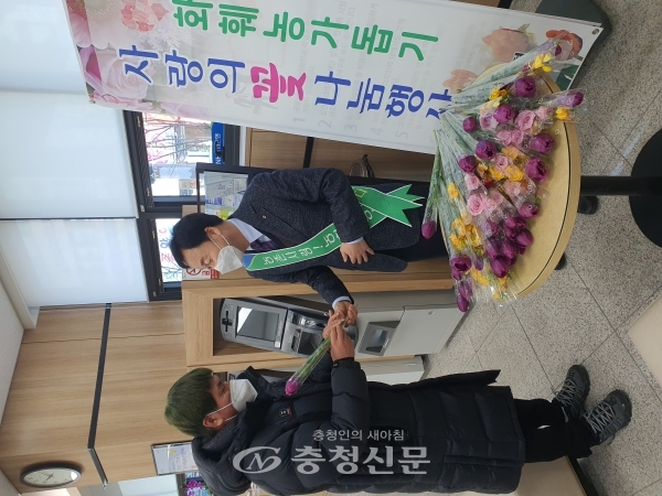 정진국 지부장이 방문고객에게 꽃을 전달하고 있다.  (사진=농협옥천군지부 제공)