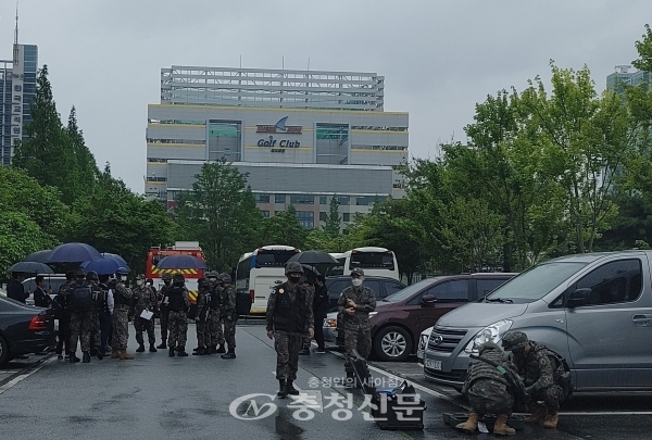 한 군부대가 20일 대전시청 인근 주차장에서 훈련을 위해 장비를 내리고 비를 피해 우산을 쓰고 옹기 종기 모여있다.(사진=김민정 기자)