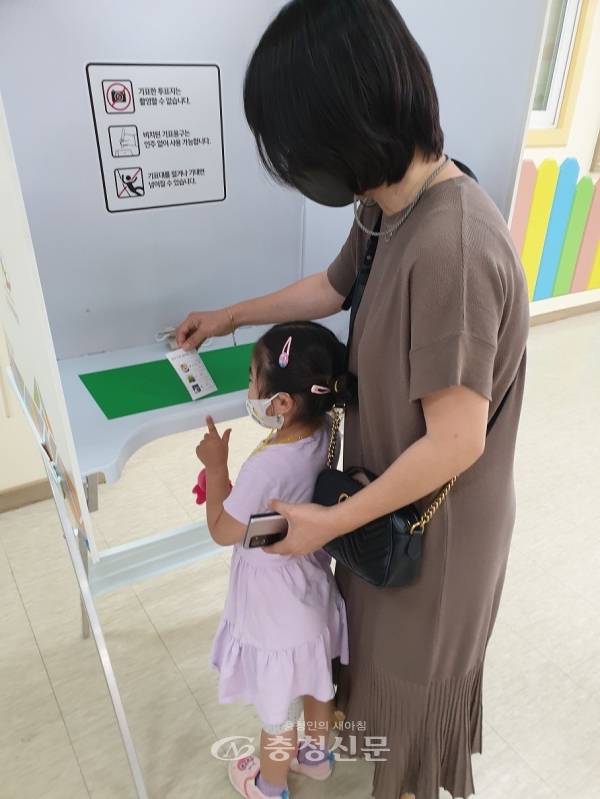 제천시육아종합지원센터를 방문한 한 어머니가 아이와 함께 투표체험에 참여하고 있다. (사진=제천시선거관리위원회 제공)