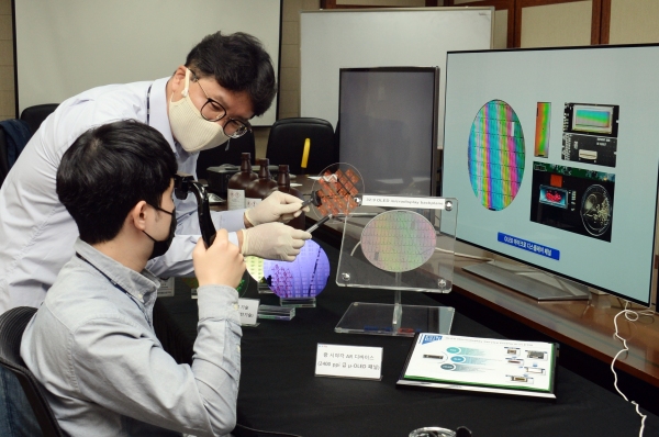 ETRI 연구진이 저온공정이 가능한 포토레지스트 소재로 OLED 디스플레이용 기판을 만들어 설명하고 있다. (사진=ETRI 제공)