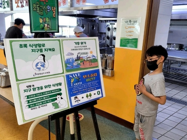 미산초등학교 급식실 입구에 설치된 초록급식 게시물을 한 어린이가 뚫어져라 관심있게 들여다보는 모습이 자못 진지하다.