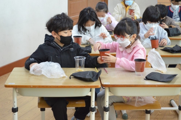 ▲ 대전도솔초 2-3반 학생들이 서로 도와가며 NON-GMO 콩나물 키우기를 제작하고 있다.(사진=노다은 기자)