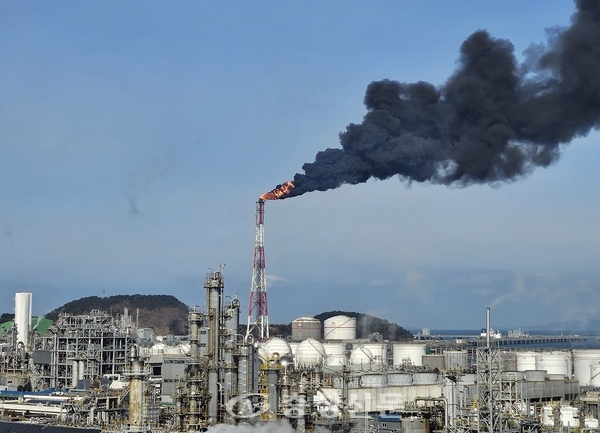 ▲25일 오전 충남 서산 대산석유화학단지 내 LG화학과 롯데케미칼에 전기 공급이 끊기면서 공장 가동이 멈춘 가운데 생산공정에 투입된 원료를 태우는 작업이 진행되면서 굴뚝에서 검은 연기가 뿜어져 나오고 있다. (연합뉴스)