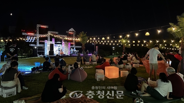 서편무대에서 관람객들이 돗자리를 깔고 버스킹을 즐기고 있다. (사진=하서영 기자)