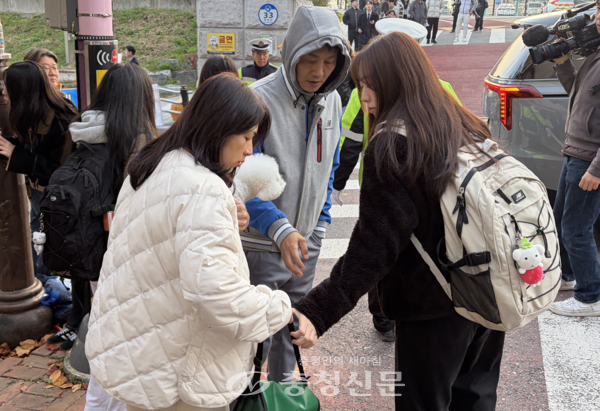 13일 동대전고등학교 교문 앞 학부모가 수험생 손에 도시락을 쥐여주고 있다. (사진=하서영 기자)